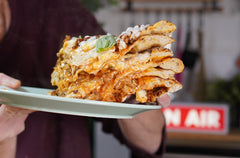 Pizzas stacked on top of each other with a beschamel sauce and ragu between layers