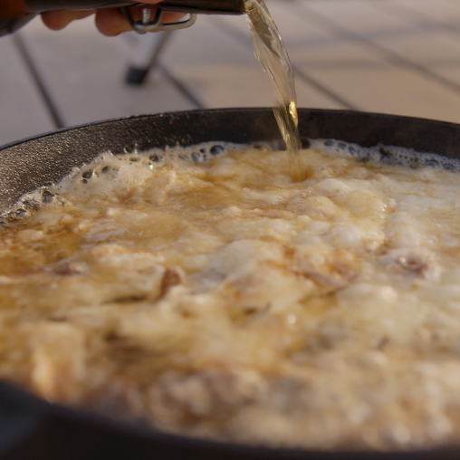 Beer and cheese fondue being cooked in Ooni cast iron skillet pan