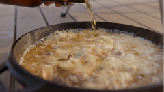Beer and cheese fondue being cooked in Ooni cast iron skillet pan