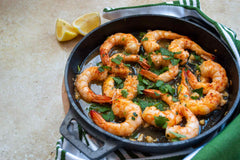 Prawns cooked in Ooni cast iron skillet pan topped with lemon and parsley