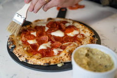 Herbed Garlic Butter Pizza Crust being applied with a pastry brush