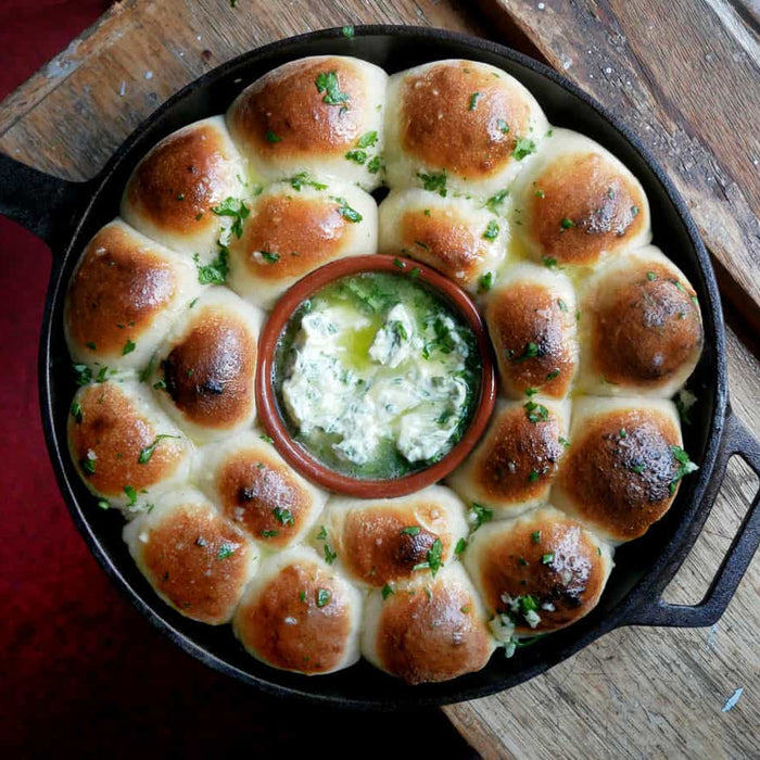 Dough balls baked in an cast iron skillet and brushed with garlic butter made using a dough balls recipe