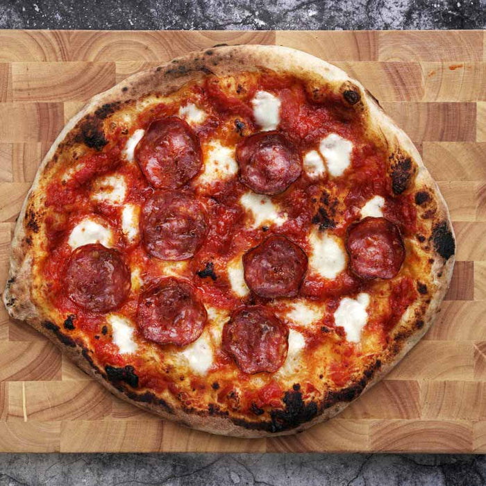 Pepperoni Pizza on a wooden chopping board baked using a pepperoni pizza recipe
