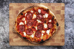 Pepperoni Pizza on a wooden chopping board baked using a pepperoni pizza recipe