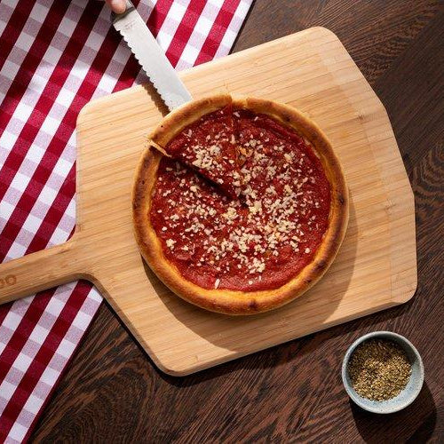 Chicago Deep Dish Pizza on a wooden pizza peel baked using a Chicago Deep Dish Pizza Recipe
