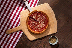 Chicago Deep Dish Pizza on a wooden pizza peel baked using a Chicago Deep Dish Pizza Recipe