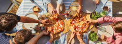 Mother and child enjoy cutting into pizza on Ooni Pizza Peel