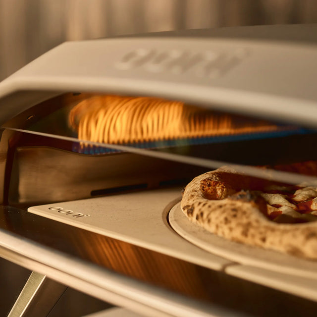 close up of flames and pizza cooking in rotating stone 