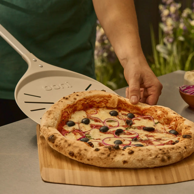 Wide 9" pizza turning peel placing pizza onto bamboo peel and serving board 