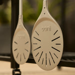 side by side of compact and wide pizza turning peel hanging from modular table. 