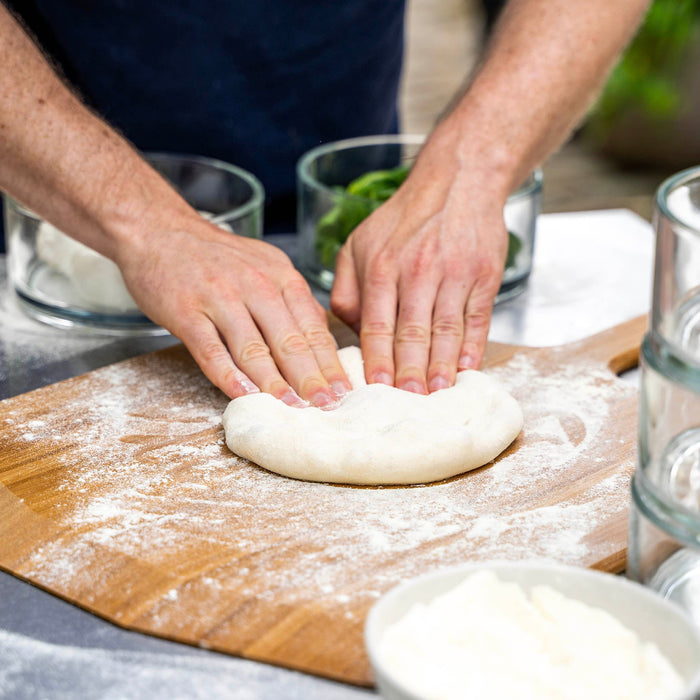 Ooni dough ball being kneaded on top of bamboo peel | Click this image to open up the product gallery modal. The product gallery modal allows the images to be zoomed in on.
