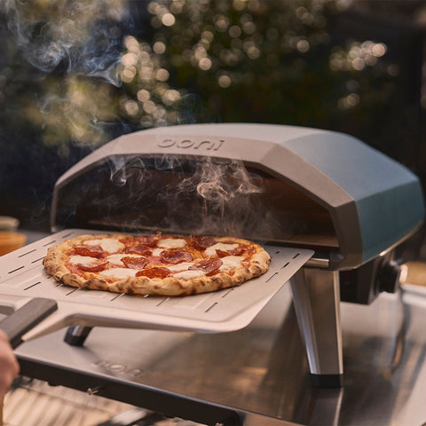Koda 2 pizza oven in slate blue with pizza on perforated peel